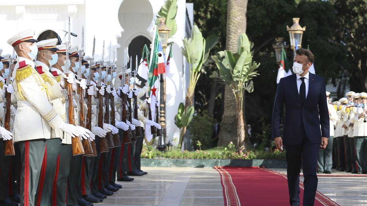 French President Emmanuel Macron reviews the troops before his talks with Algerian President Abdelmajid Tebboune on Thursday in Algiers. — AP