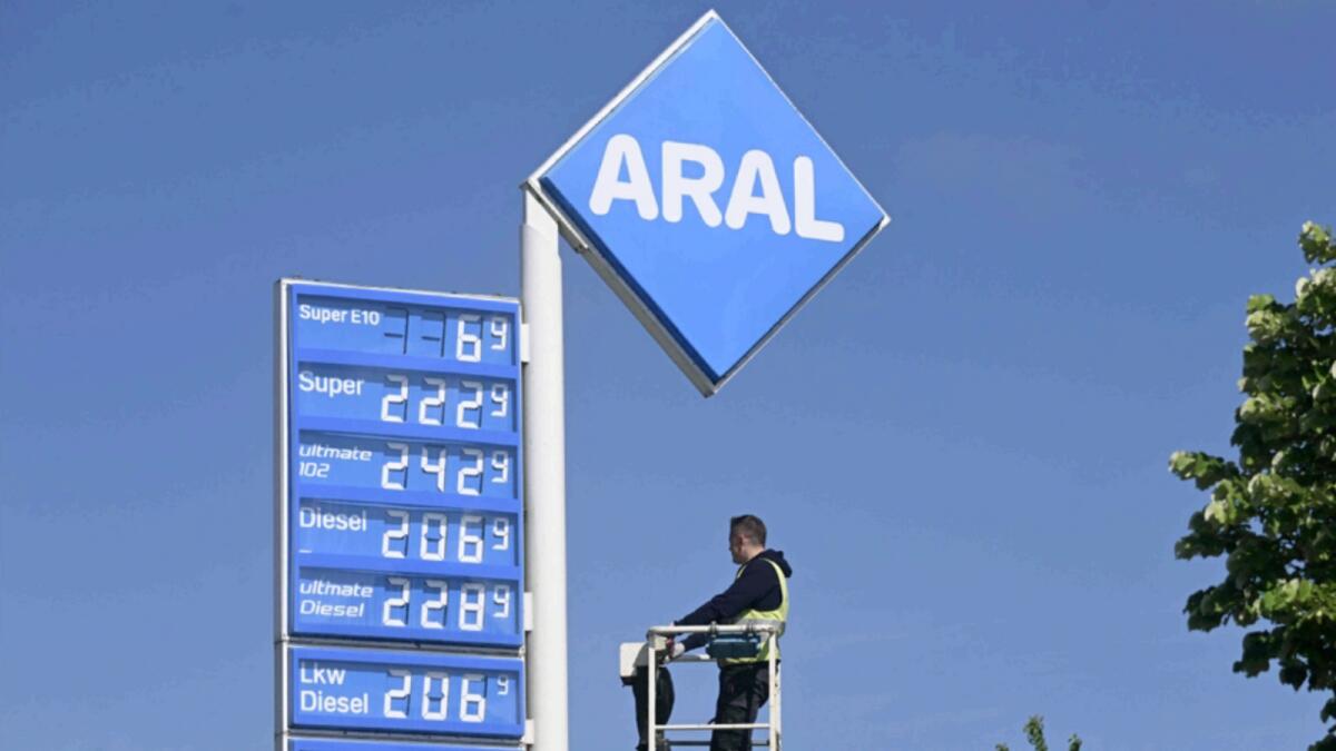 An employee checks a display which shows the prices for various fuels at a petrol station near the Bavarian village of Olching, southern Germany. — AFP