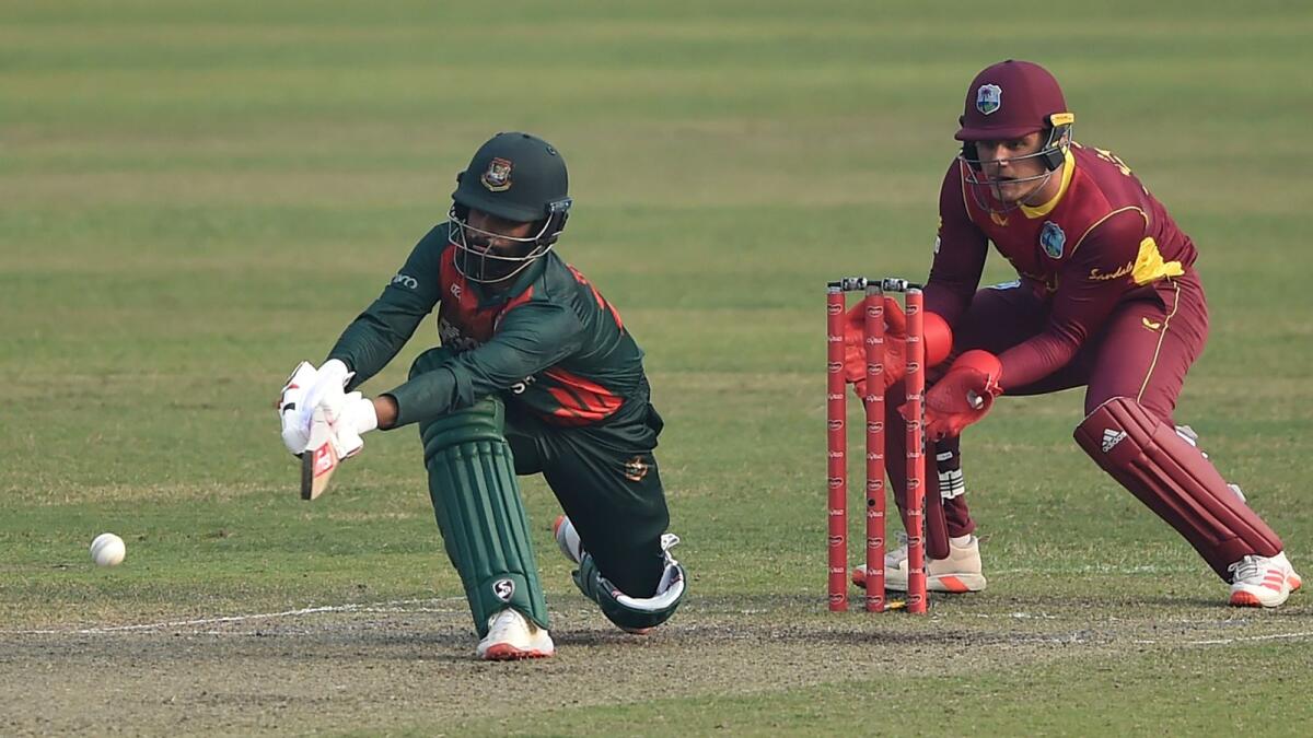 Bangladesh's captain Tamim Iqbal plays a shot as West Indies' wicketkeeper Joshua Da Silva looks on. —  AFP