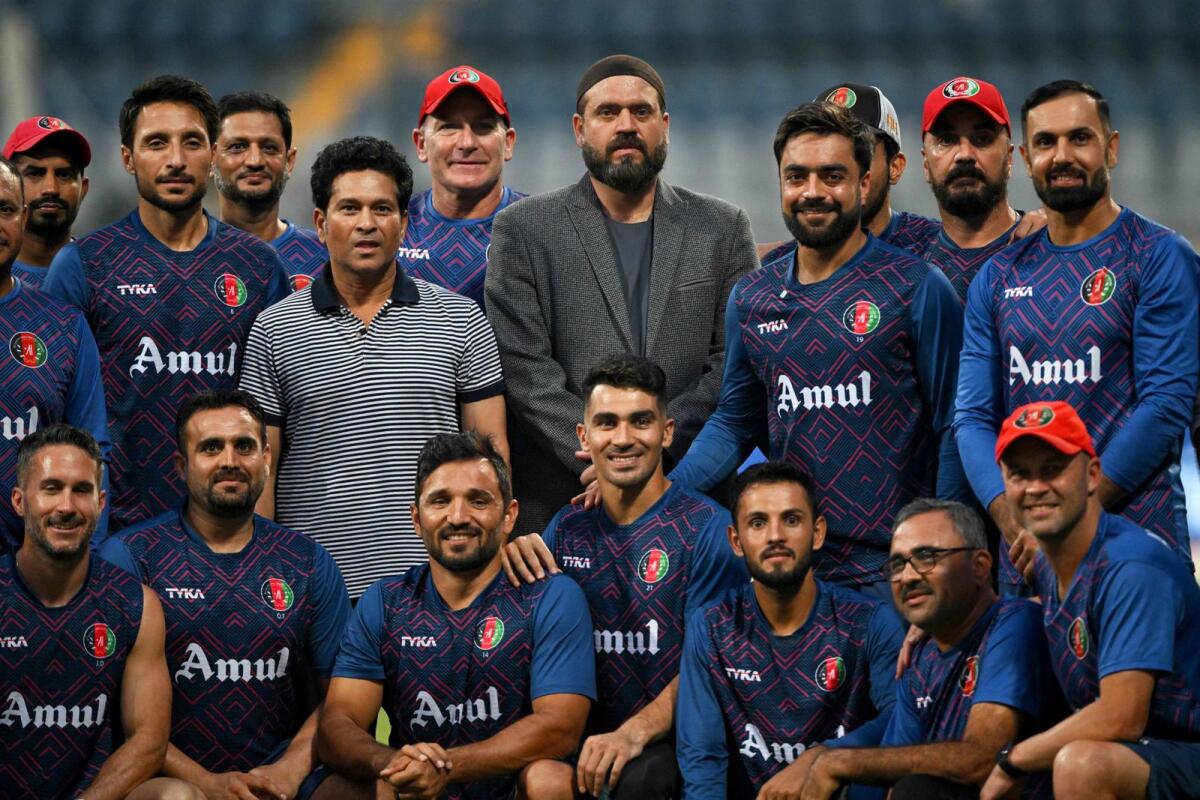 Indian cricket legend Sachin Tendulkar poses for a photograph with Afghanistan players during a practice session at the Wankhede Stadium in Mumbai. — AFP