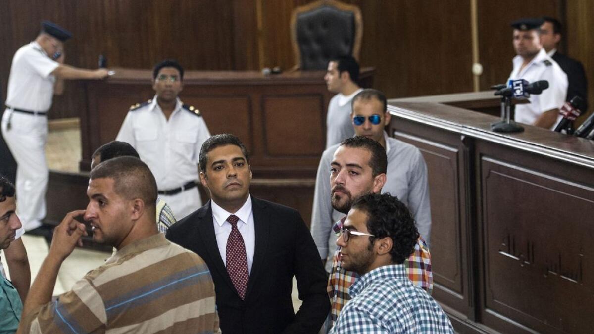 Al Jazeera journalists, Canadian Mohamed Fahmy (C) and Egyptian Baher Mohamed (C-R), attend their trial in the capital Cairo. 