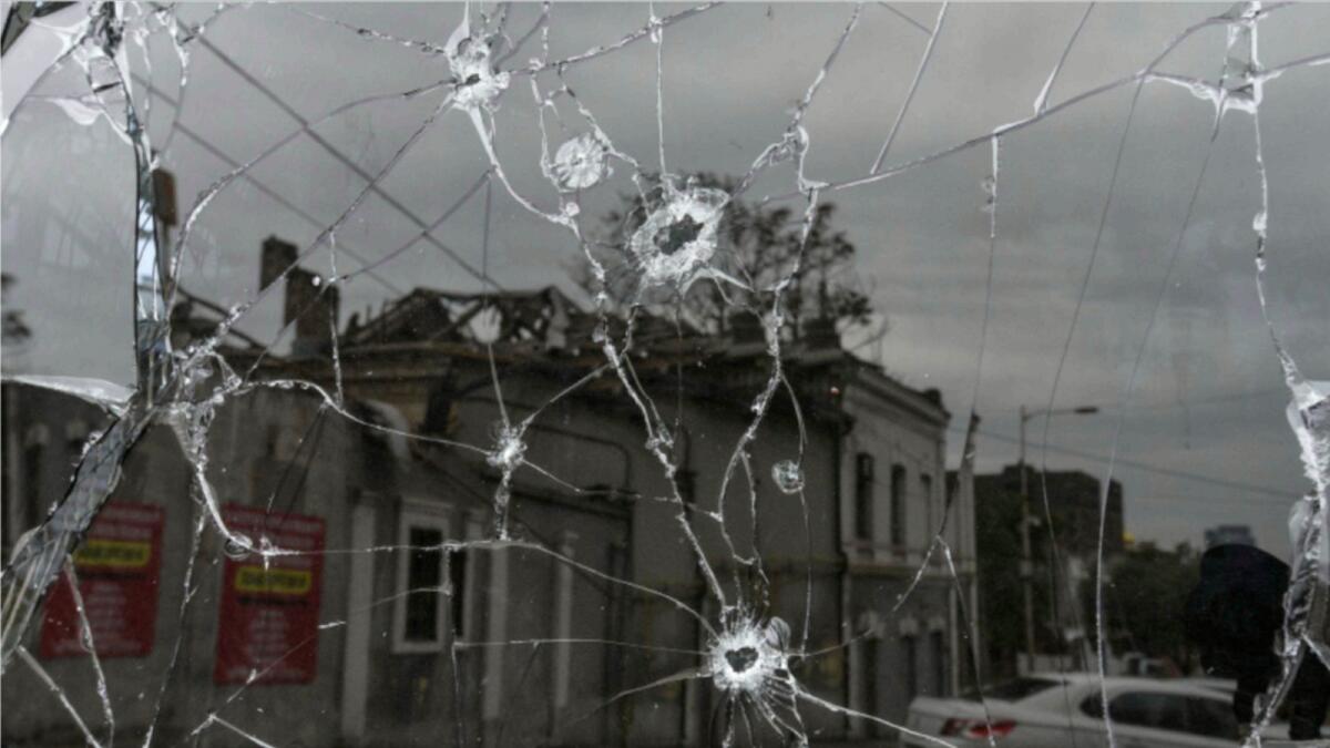 A building damaged by a Russian missile strike is reflected in a window broken with shrapnel. — Reuters