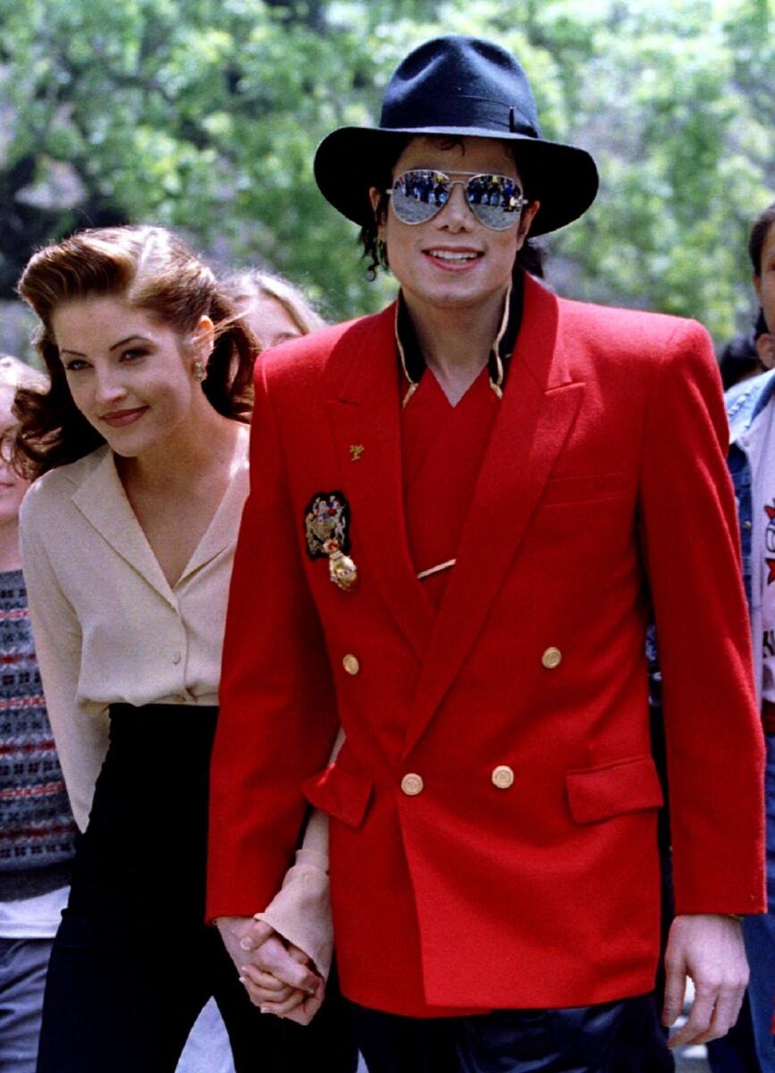 Michael Jackson and his wife Lisa Marie Presley-Jackson hold hands April 18 as they welcome childre for the World Children's Conference at Jackson's Neverland Valley Ranch in Los Olivos, California April 18, 1995.