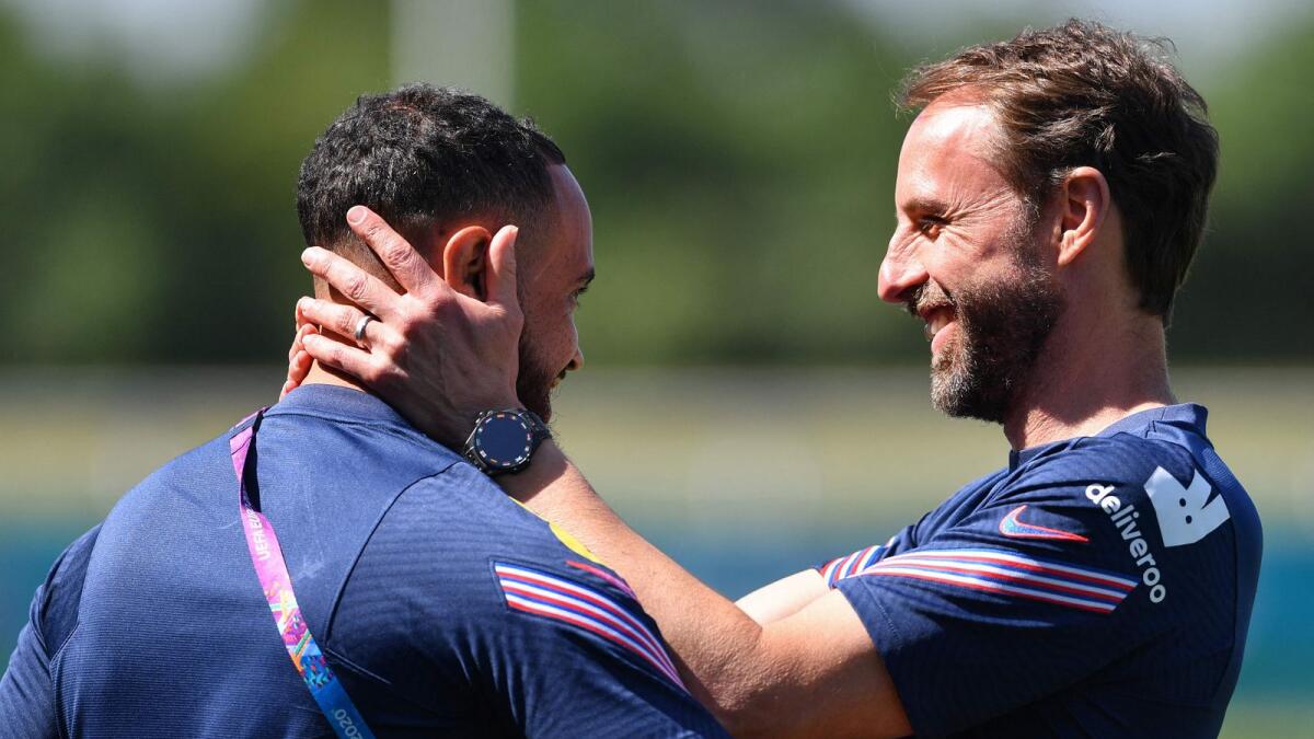 England coach Gareth Southgate (right) embraces a staff member during a training session at St George's Park. (AFP)