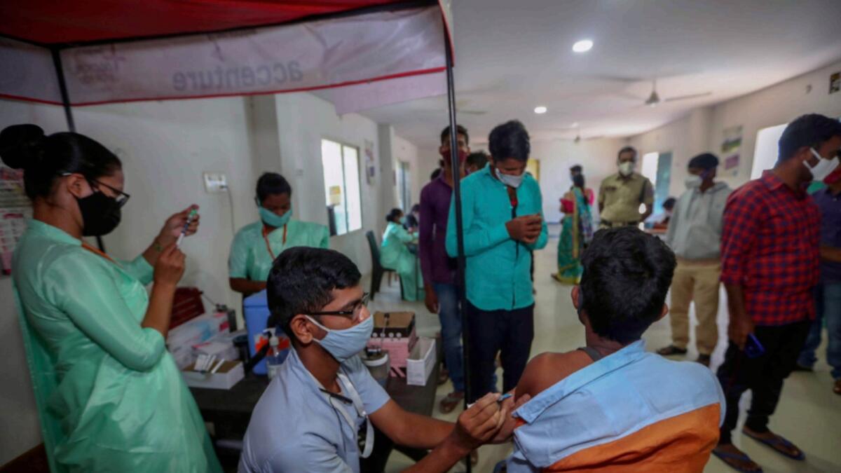 A health worker administers Covid-19 vaccine as other await the turn in Hyderabad. — AP