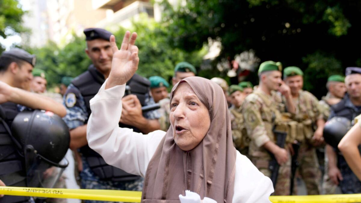 A depositor protests outside a bank where another armed man holds hostages in Beirut. — AP