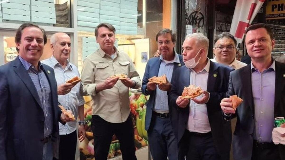 Jair Bolsonaro (3rd from left) eats pizza with his delegation on the sidewalk in New York ahead of the UN General Assembly. — Courtesy: Twitter