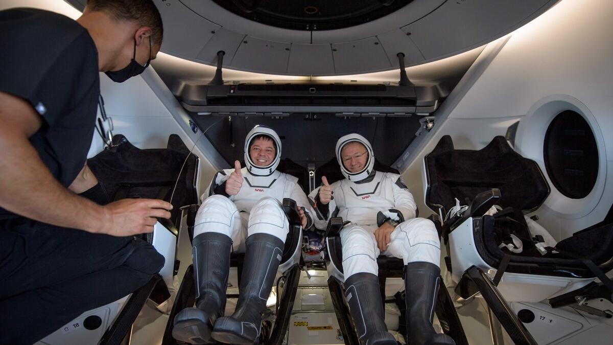 NASA astronauts Robert Behnken and Douglas Hurley are seen inside the SpaceX Crew Dragon Endeavour spacecraft onboard the SpaceX GO Navigator recovery ship shortly after having landed.