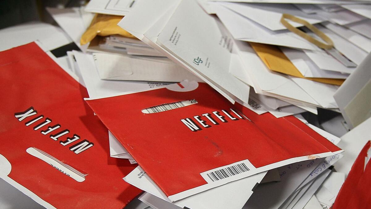 Red Netflix envelopes sit in a bin of mail at the US post office sort centre in San Francisco, California. Netflix has finally called time on the movie mail-out subscription business that launched today's Hollywood streaming colossus. - AFP