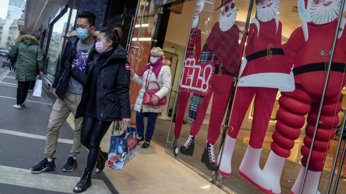 People wearing face masks to protect against Covid-19 walk out of a shopping center in Paris. — AP