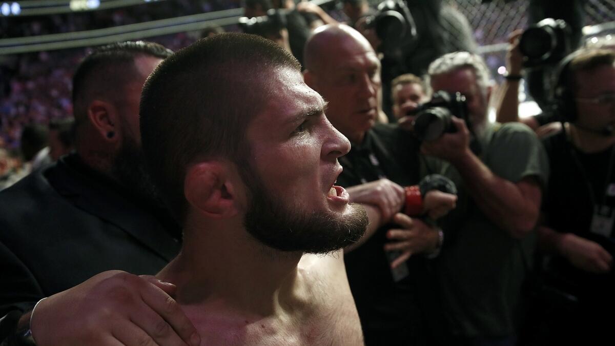 Nurmagomedov is held back outside of the cage after beating McGregor at UFC 229. (AP)