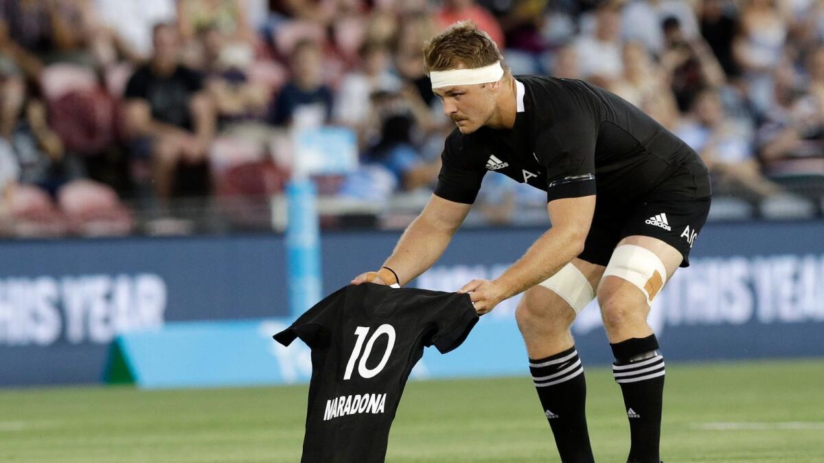 New Zealand captain Sam Cane lays All Black number 10 jersey on the pitch in memory of Diego Maradona prior to the start of the Tri-Nations rugby test between Argentina and the All Blacks on Saturday. (AP)