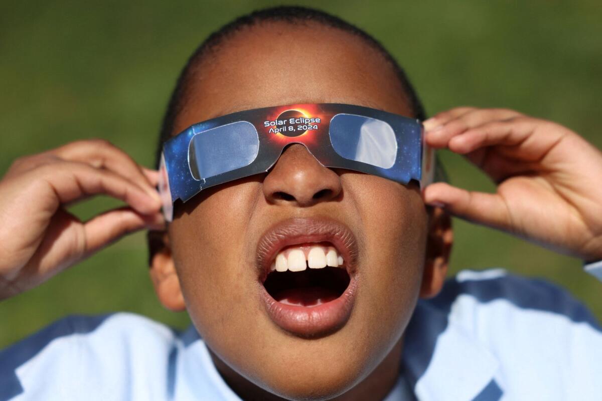 Adrian Plaza, 9, of Queens, tests his eclipse glasses