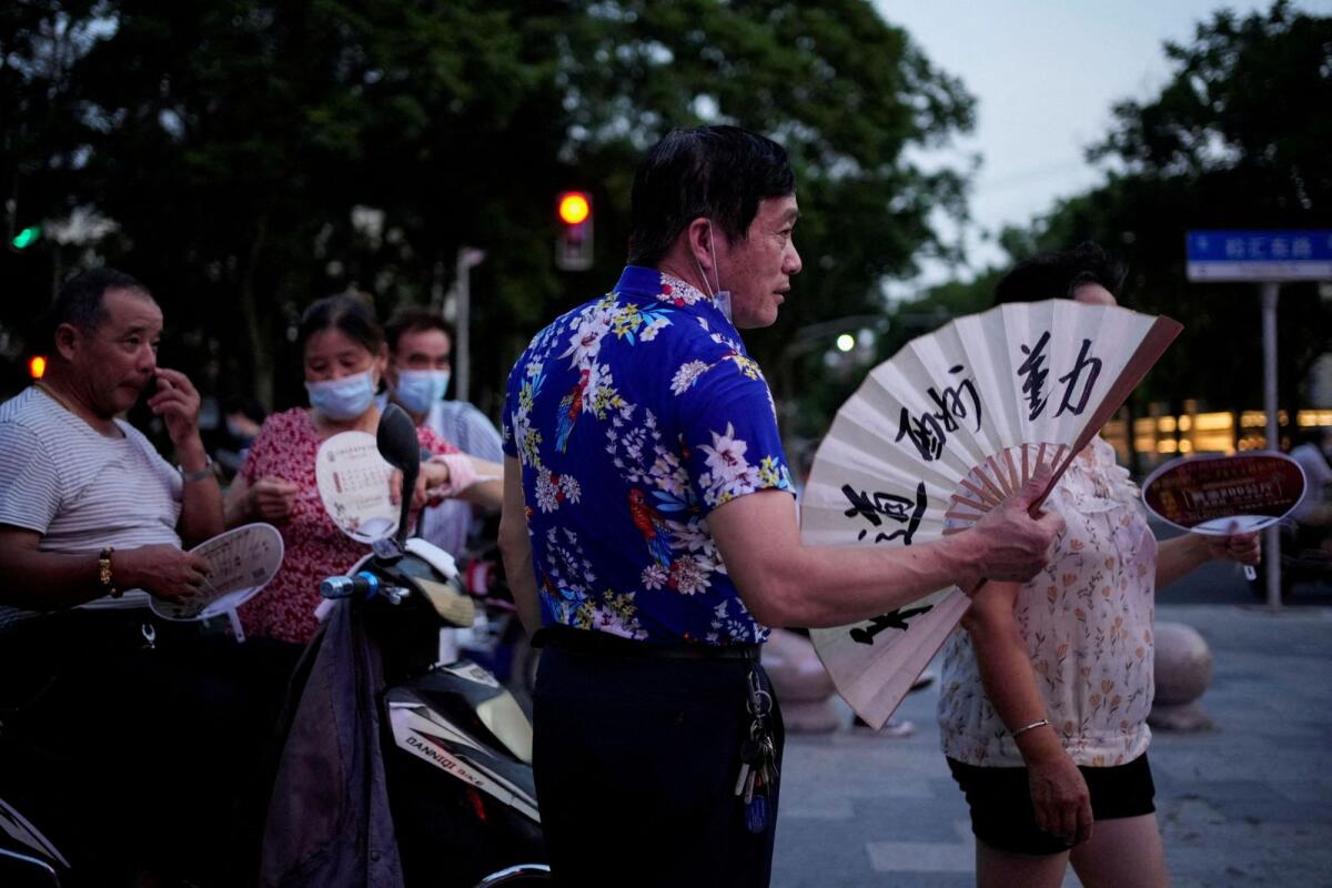 People use fans as they gather in a park amid a heatwave warning in Shanghai, China, on  July 23, 2022.  Photo: Reuters