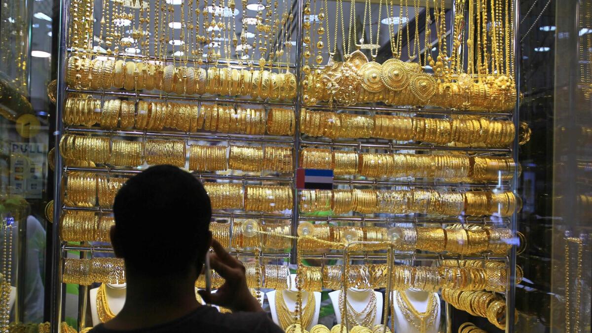 A man looks at the gold ornaments displayed in a shop at the Gold Souq in Dubai.- Photo by Neeraj Murali/ Khaleej Times