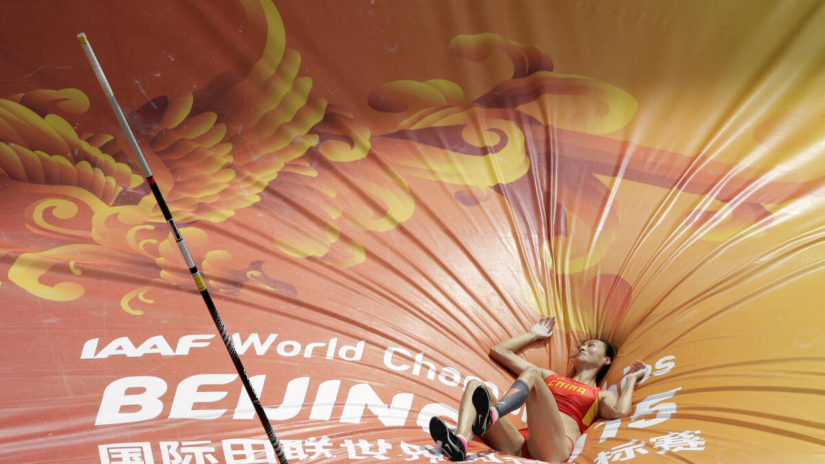 China's Li Ling lays on the mat after an attempt in women's pole vault qualification at the World Athletics Championships at the Bird's Nest stadium in Beijing on Aug. 24, 2015. 