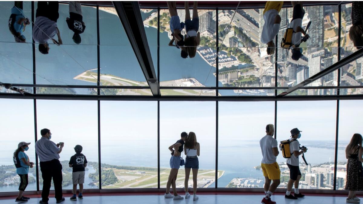 Visitors view panoramic city scenes from the 553 metres (1815 feet) high CN Tower, which reopened for the first time since the coronavirus disease (Covid-19) restrictions were imposed in Toronto, Ontario, Canada. Photo: Reuters