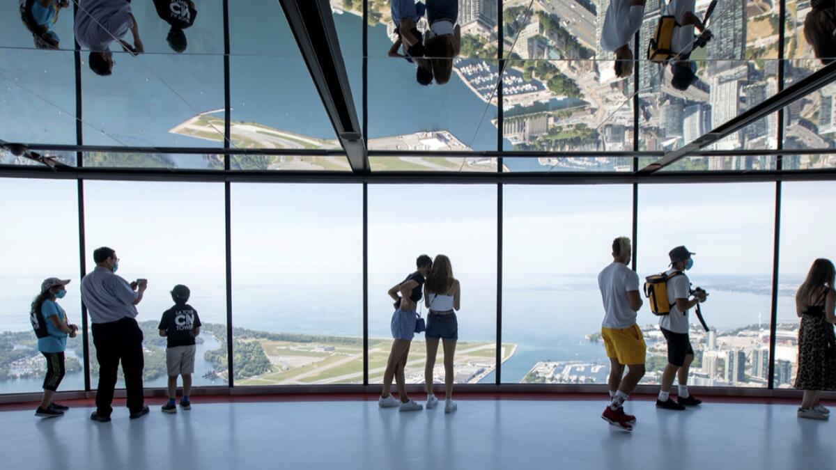 Visitors view panoramic city scenes from the 553 metres (1815 feet) high CN Tower, which reopened for the first time since the coronavirus disease (Covid-19) restrictions were imposed in Toronto, Ontario, Canada. Photo: Reuters