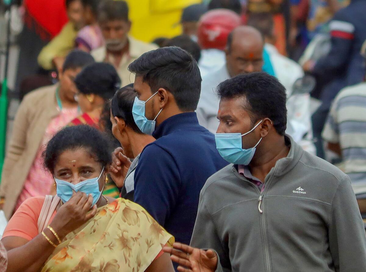 People wearing face masks as a precautionary measure after cases of Covid-19 sub-variant JN.1 were detected in the country, in Bengaluru. Photo: PTI
