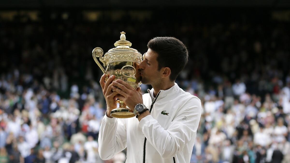 Novak Djokovic kisses the trophy after defeating Switzerland's Roger Federer in the men's singles final match of the Wimbledon Tennis Championships in London. AP
