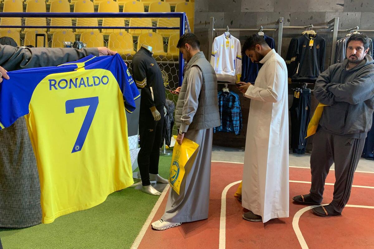 A fan holds a t-shirt bearing the name Ronaldo at the Saudi Al Nassr FC shop in Ryadh on Saturday. — AFP