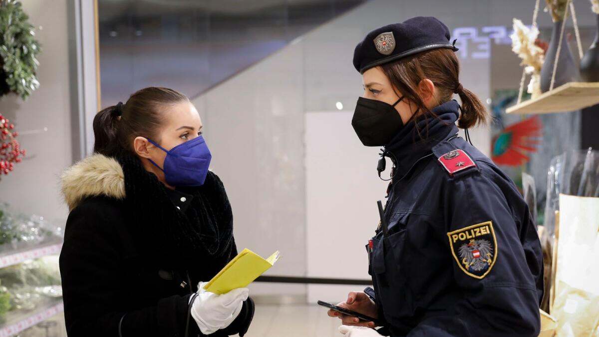 A police officer checks the vaccination status of a visitor during a patrol in a shopping mall in Vienna, Austria. – AP