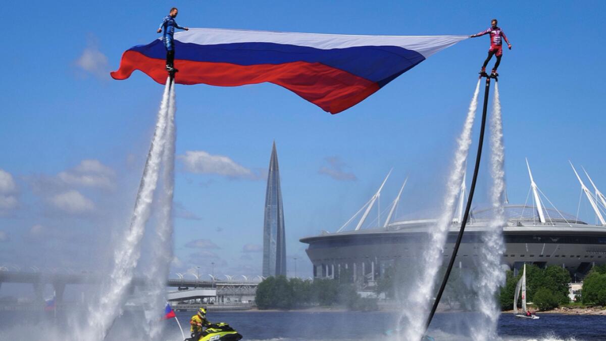 St.Petersburg: Members of the Russian hydroflight team hold the Russian national flag during the Day of Russia celebration in St.Petersburg, Russia, Friday, June 12, 2020. Photo: AP