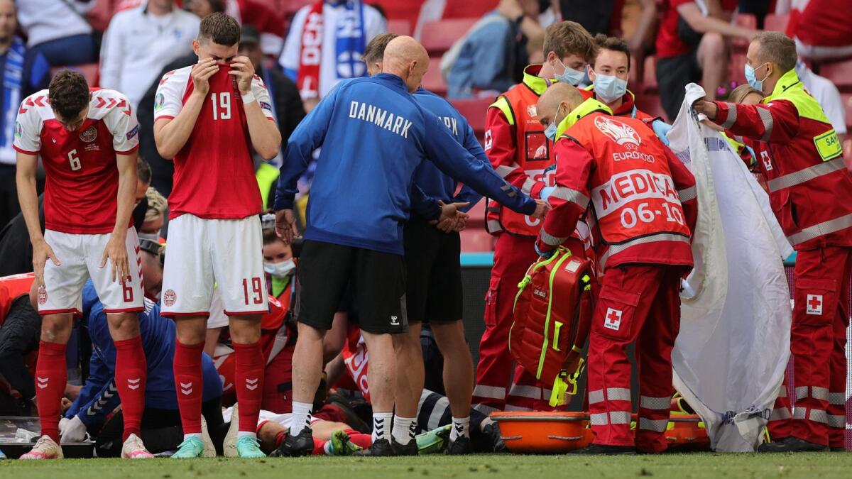 Denmark's players react as paramedics attend to Christian Eriksen after he collapsed on the pitch during the Euro match against Finland. (AFP)