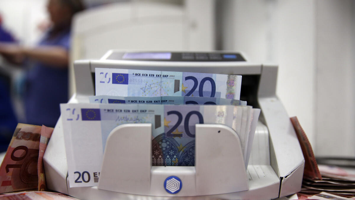 Twenty euro banknotes pass through an automated currency counting machine in this arranged photograph taken inside a Travelex store, operated by Travelex Holdings Ltd., in London, U.K., on Monday, Jan. 12, 2015. The euro approached a nine-year low against the dollar as European Central Bank officials fueled speculation the institution will start a program of government-bond buying as early as next week to stave off deflation. Photographer: Simon Dawson/Bloomberg
