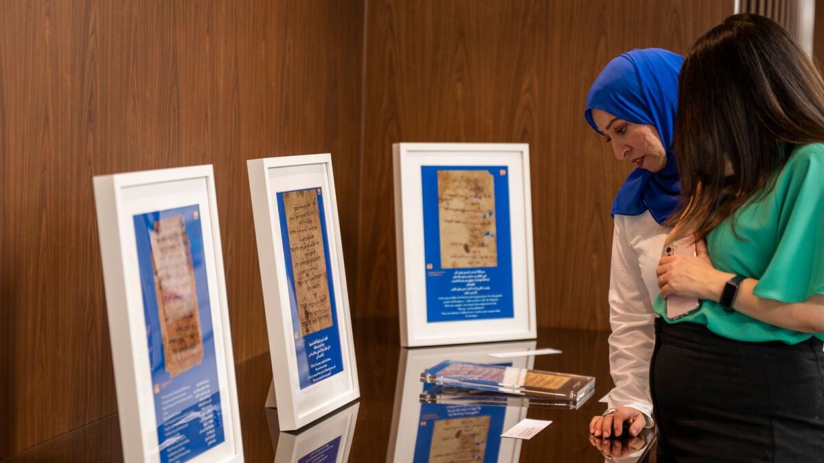 Two women check out the remarkable collection of medieval manuscripts discovered at the end the 19th century in a synagogue in Al-Fustat, Old Cairo, at the Hidden Literature exhibition. — Photo by Shihab