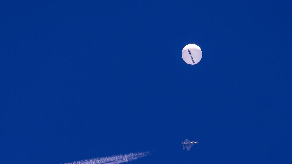 A fighter jet flies near a large balloon drifting above the Atlantic Ocean, just off the coast of South Carolina near Myrtle Beach, on February 4, 2023.— AP FILE