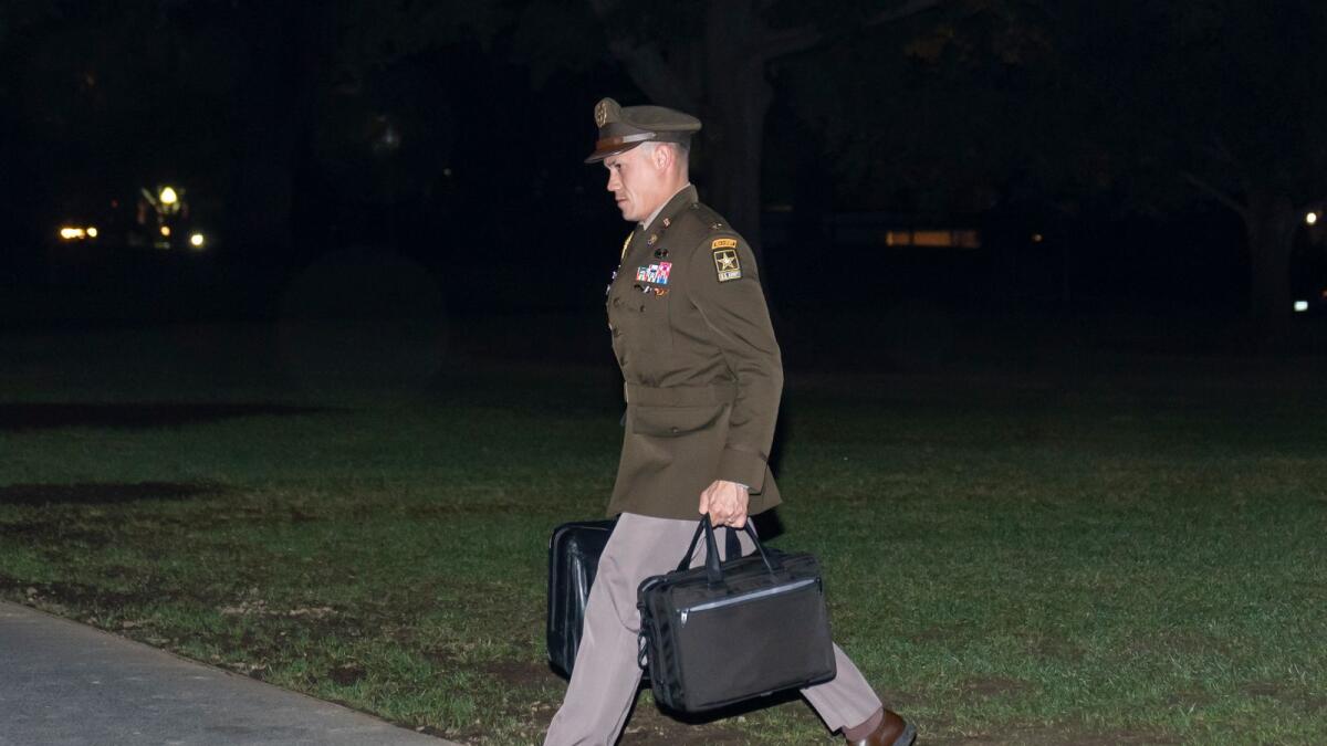 A US Army officer military aide carries the nuclear launch codes known as the 'football,' as he follows President Joe Biden into the White House after arriving on Marine One on Thursday in Washington. — AP