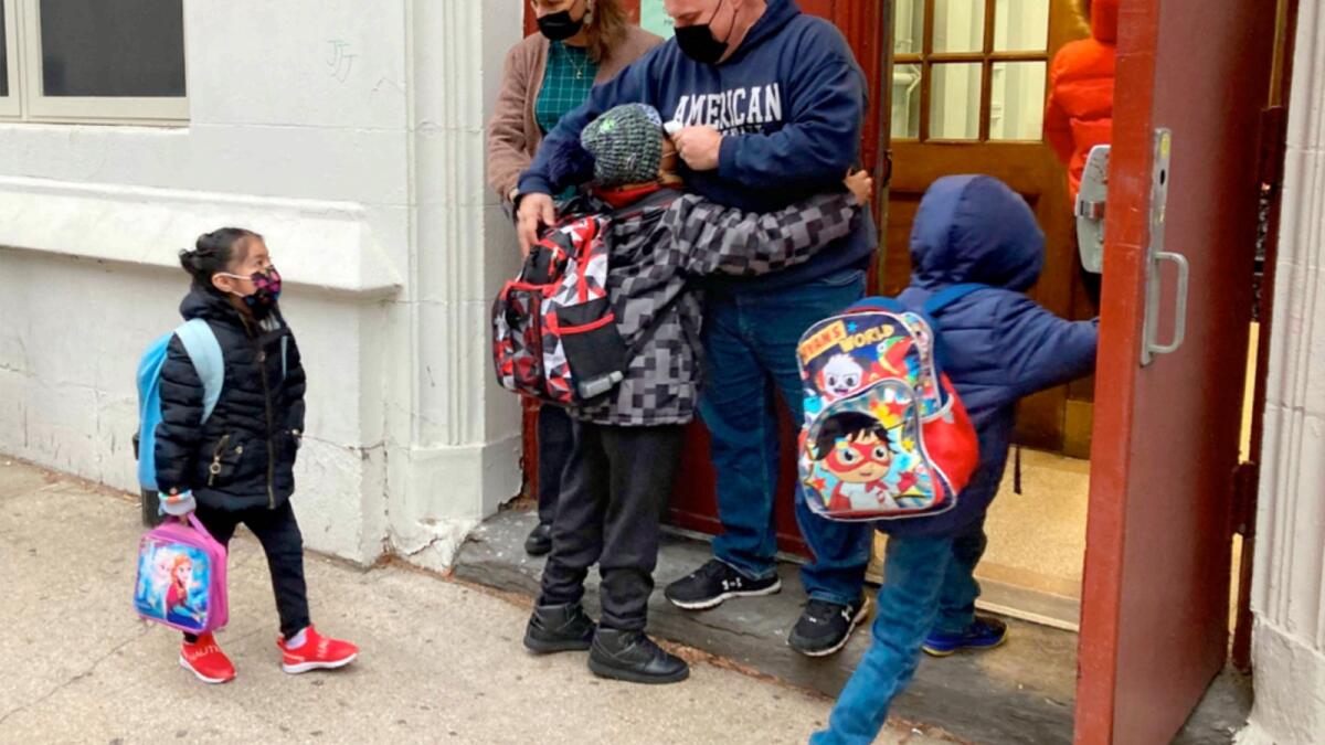 John Marro, the dean of students at  The American Sign Language and English Lower School in New York takes students' temperatures as they arrive on the first day after the holiday break on Monday. — AP