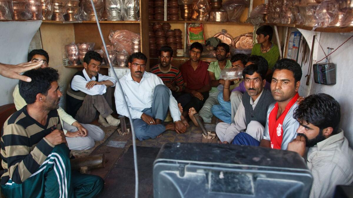 People watching television in a shop in India. Photo: Alamy