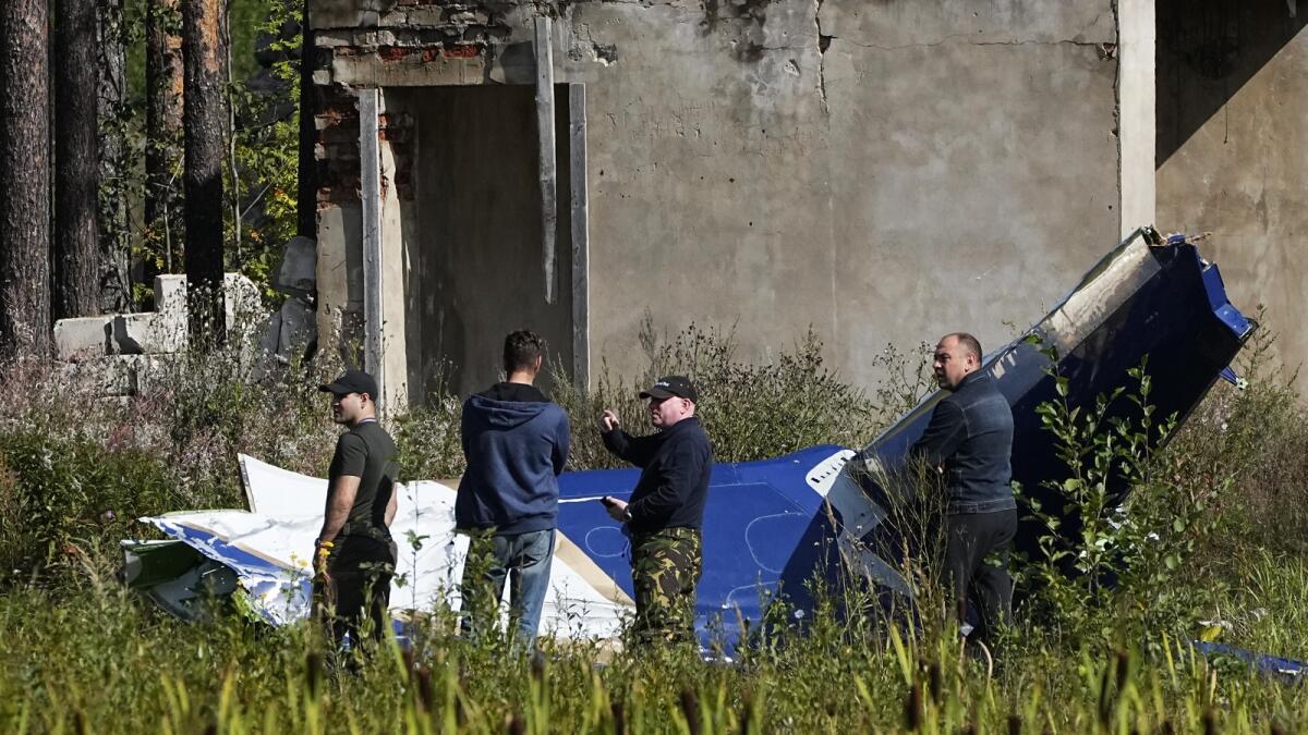 Russian investigators inspect a part of a crashed private jet near the village of Kuzhenkino, Tver region, Russia. — AP