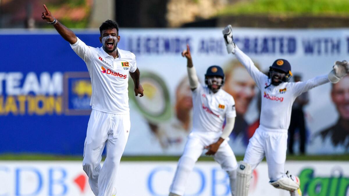Sri Lanka's Ramesh Mendis (left) celebrates after taking the wicket of Australia's David Warner. (AFP)