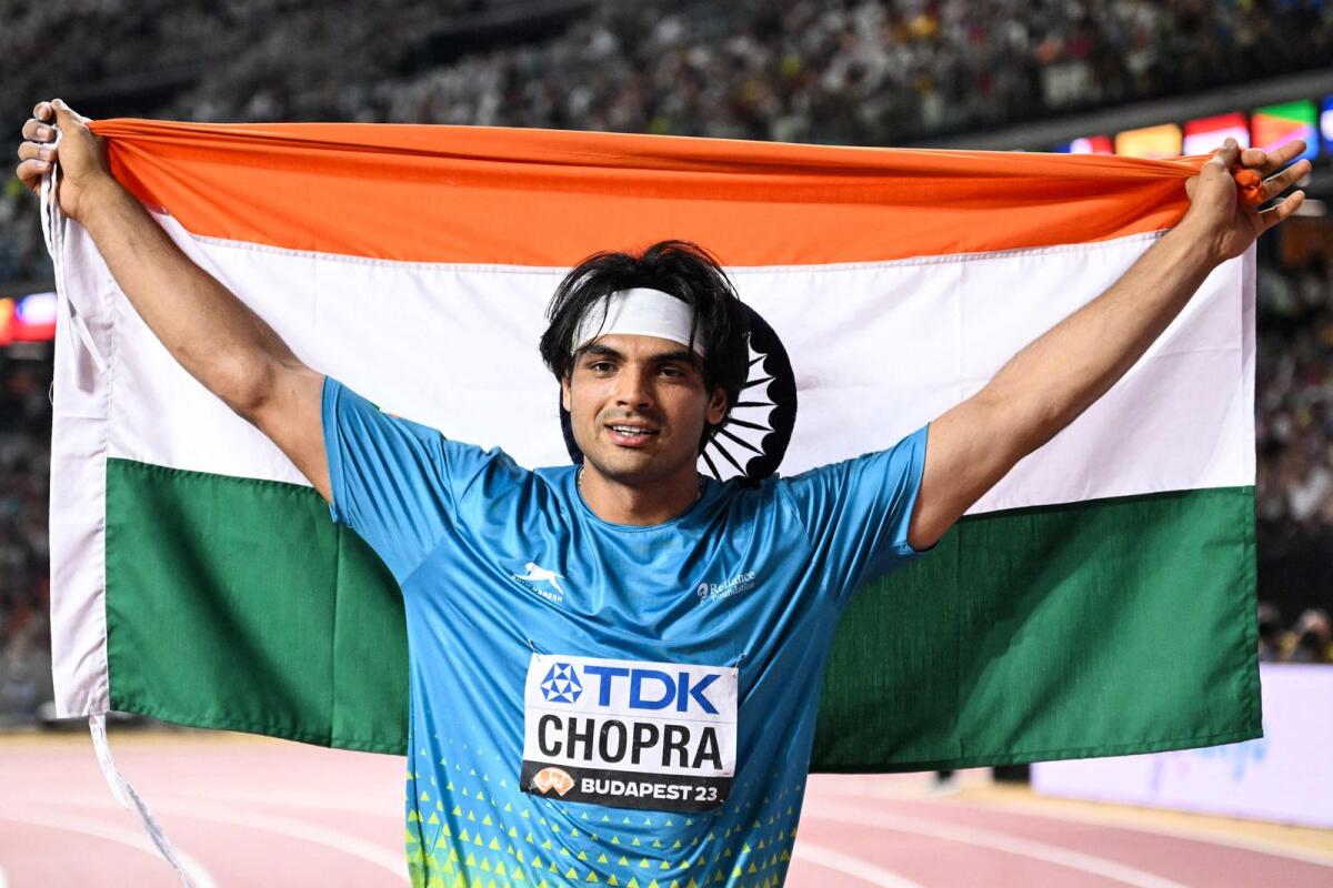 India's Neeraj Chopra celebrates with his national flag after winning the men's javelin throw final at the World Athletics Championships last month. — AFP