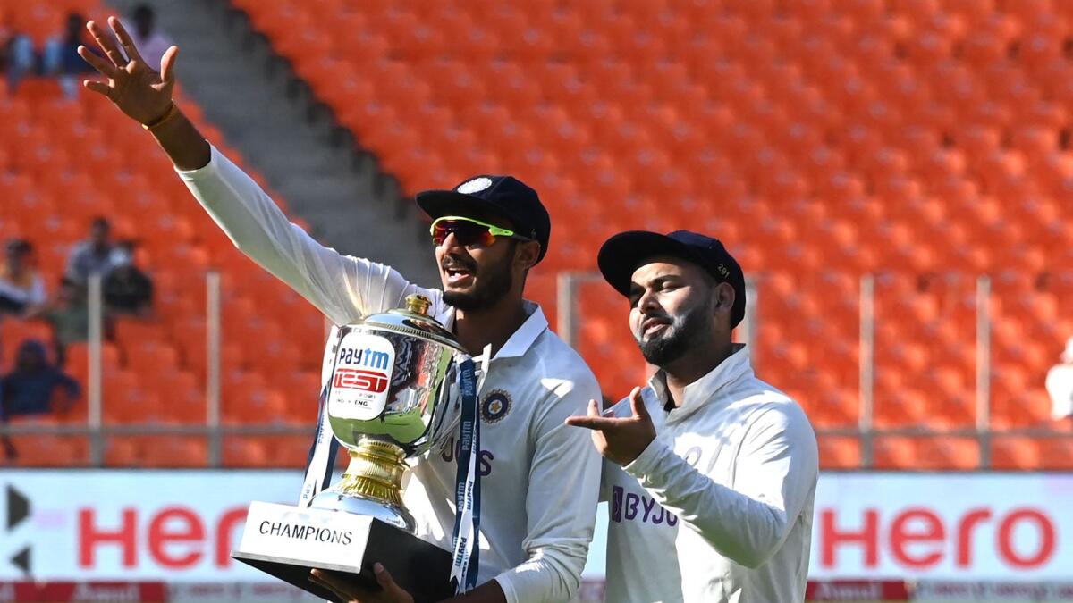 India's Axar Patel (left) and teammate Rishabh Pant pose with the trophy after winning the Test series against England. — AFP