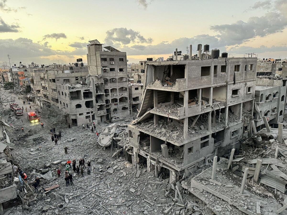 Palestinians walk at the site of Israeli strikes on houses, in Jabalia refugee camp in the northern Gaza Strip November, 21, 2023. Photo: Reuters