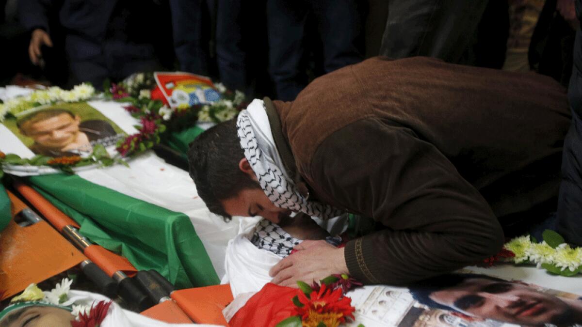 A relative reacts at the body of a Palestinian, during his funeral in the West Bank city of Hebron.