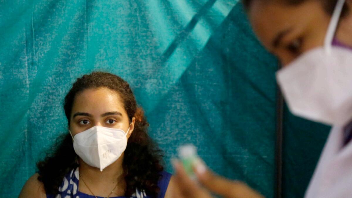 A woman waits to receive a dose of Covishield vaccine in Ahmedabad. — AP