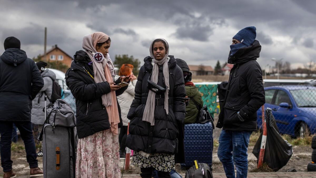 Indian girls wait for transport as refugees from many diffrent countries - from Africa, Middle East and India - mostly students of Ukrainian universities arrive at the Medyka pedestrian border crossing fleeing the conflict in Ukraine, in eastern Poland on February 27, 2022. Photo: AFP