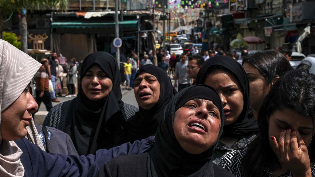 People mourn the death of two Palestinians killed by Israeli troops during their funeral. — AFP