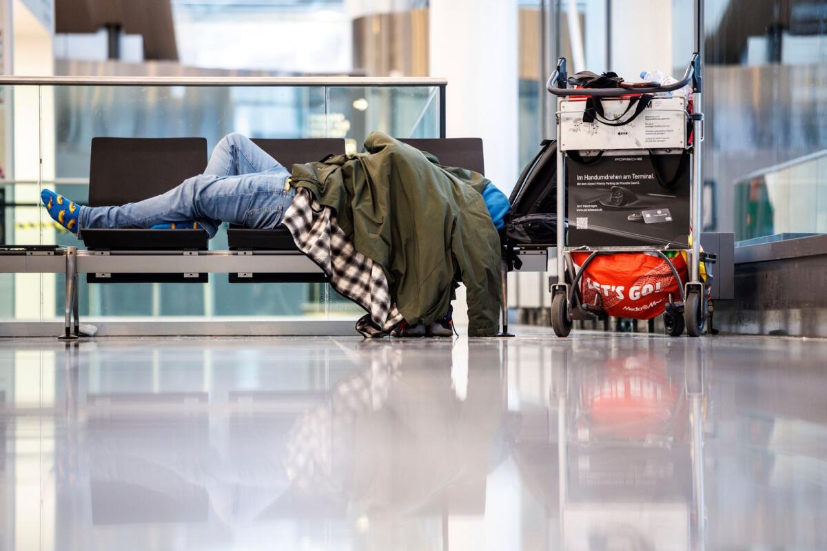 A person sleeps on a bench in the departure hall at Munich Airport, Germany, Wednesday, Jan. 17, 2024. — AP