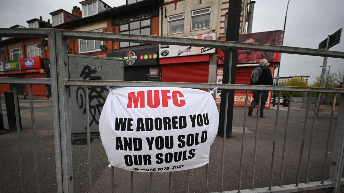 A banner against the proposed European Super League hangs from railings close to Manchester United's Old Trafford stadium in Manchester. — AFP