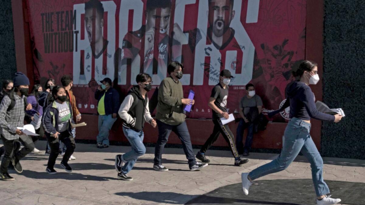 Youngsters rush to queue to get vaccinated against Covid-19 during a vaccination drive at the Caliente Stadium in Tijuana, Baja California state, Mexico. — AFP