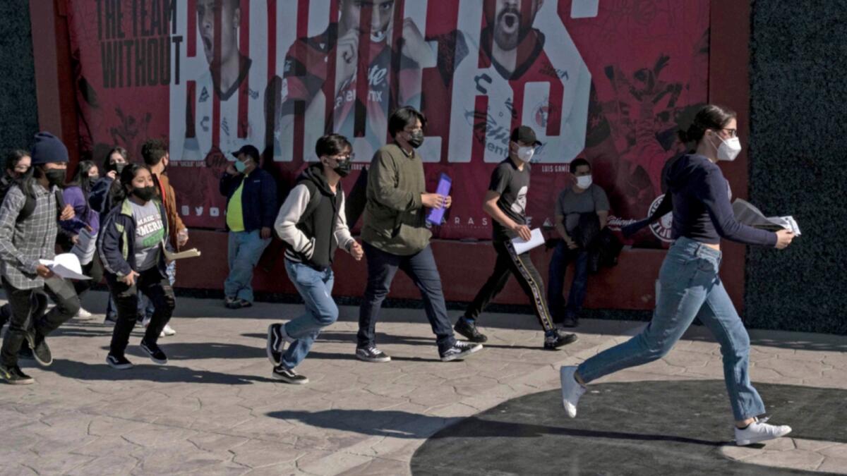 Youngsters rush to queue to get vaccinated against Covid-19 during a vaccination drive at the Caliente Stadium in Tijuana, Baja California state, Mexico. — AFP
