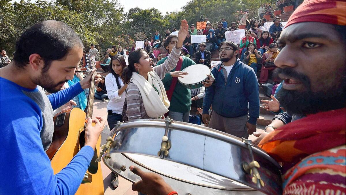 JNU students and teachers (centre) agitating for the release of the Students Union president Kanhaiya Kumar at the campus in New Delhi. At extreme right, police detain ABVP students during their protest rally over the JNU row at Osmania University Campus in Hyderabad on Tuesday. — PTI, AP