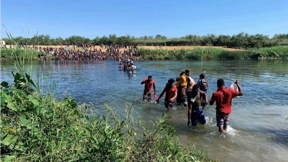 Migrants find an alternate place to cross from Mexico to the United States after access to a dam was closed. — AP file