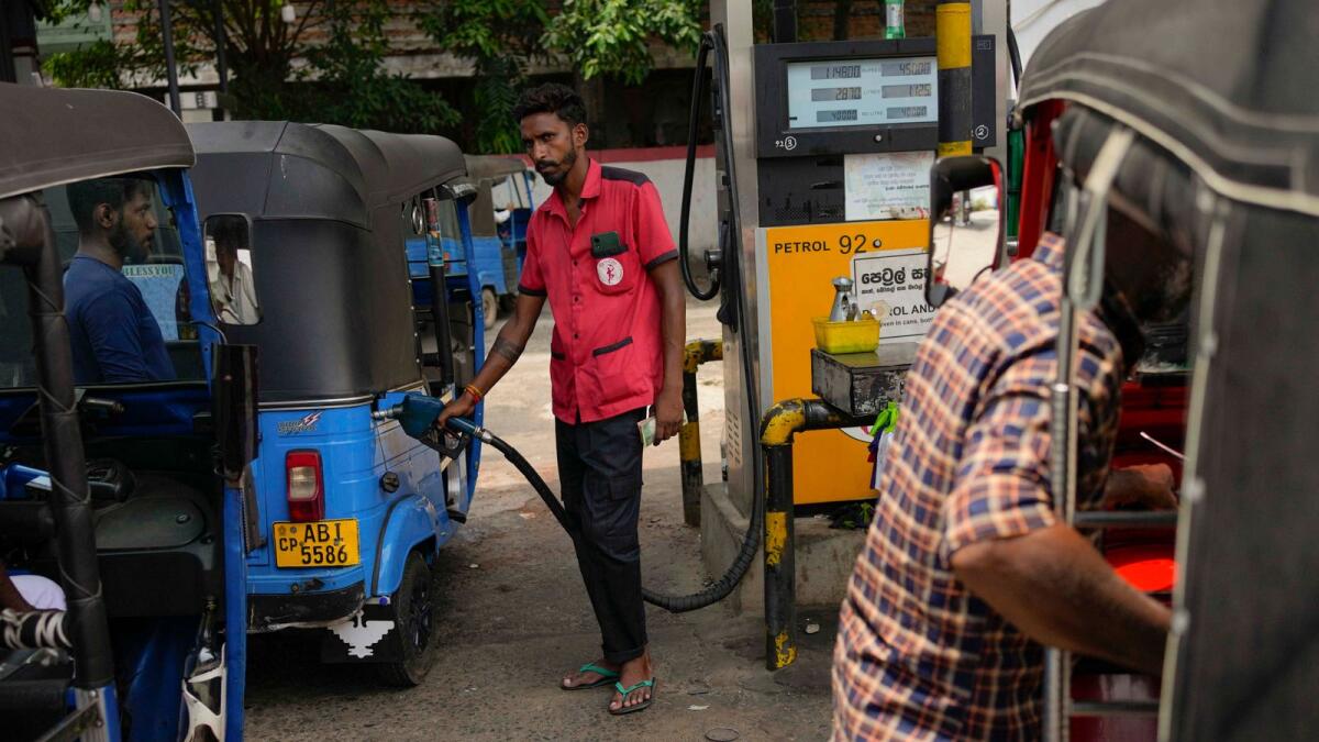 A man fills gas into a vehicle at a fuel station in Colombo, Sri Lanka. - AP